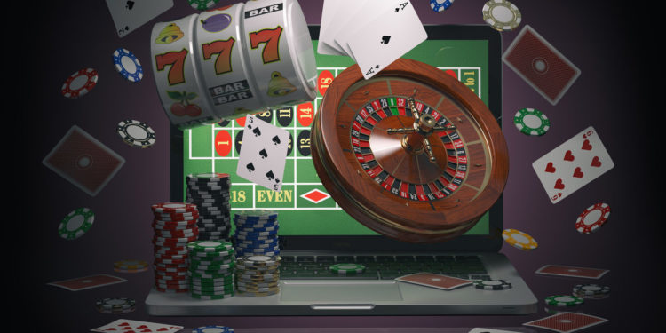 Conceito de casino online. Laptop com roleta, caça-níqueis, fichas de cassino e cartas de jogar isoladas no fundo preto. Ilustração 3D
